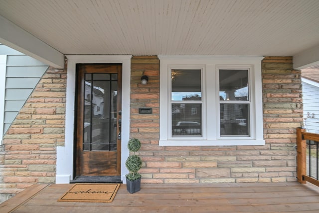 doorway to property featuring stone siding and brick siding