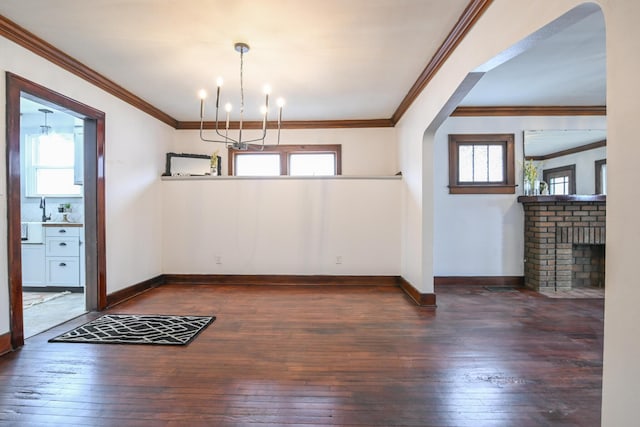 unfurnished dining area with arched walkways, plenty of natural light, and dark wood finished floors