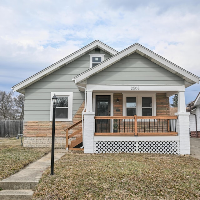 bungalow-style home with a porch and a front lawn