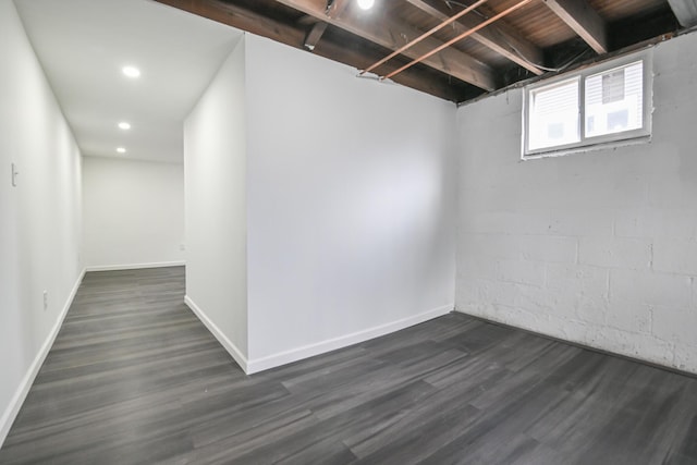 basement featuring baseboards, dark wood finished floors, and recessed lighting