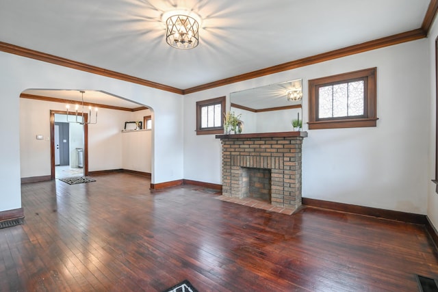 unfurnished living room featuring baseboards, arched walkways, dark wood-type flooring, a fireplace, and a notable chandelier