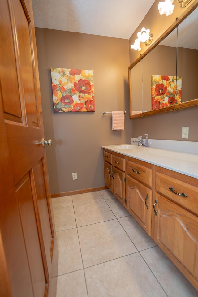 bathroom featuring baseboards, tile patterned flooring, and vanity