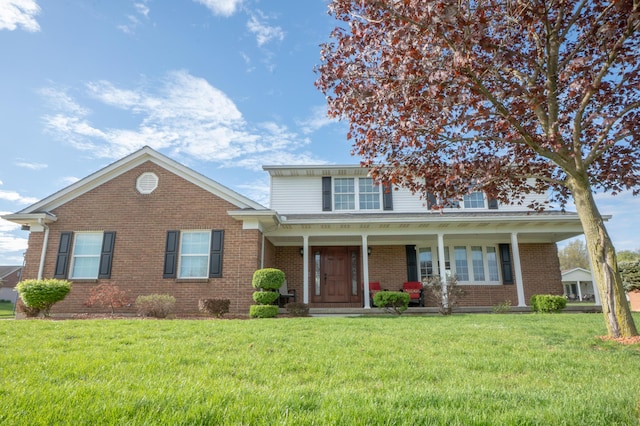 traditional-style house featuring brick siding, a front lawn, and a porch