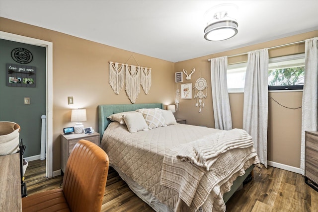 bedroom with baseboards and wood finished floors