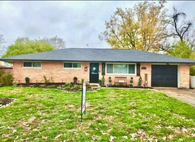 ranch-style home with concrete driveway, a front lawn, and an attached garage