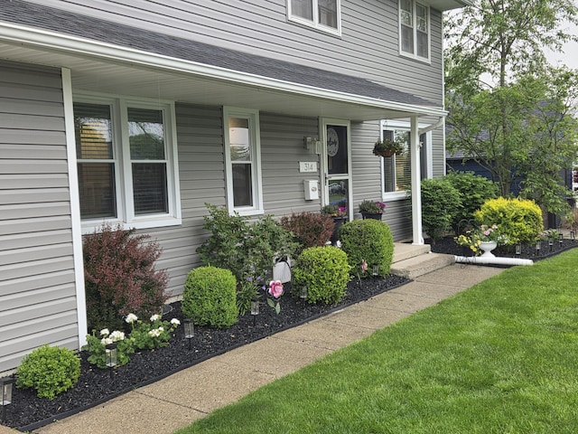 314 Concord Ave, Saint Marys, OH 45885 - property entrance with a porch, roof with shingles, and a lawn