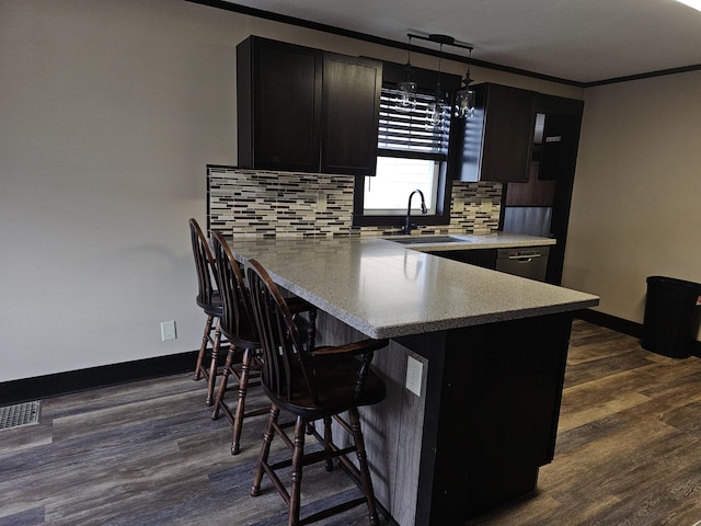 2 E Main St, Fletcher, OH 45326 - kitchen with dark cabinetry, a breakfast bar, backsplash, a peninsula, and crown molding