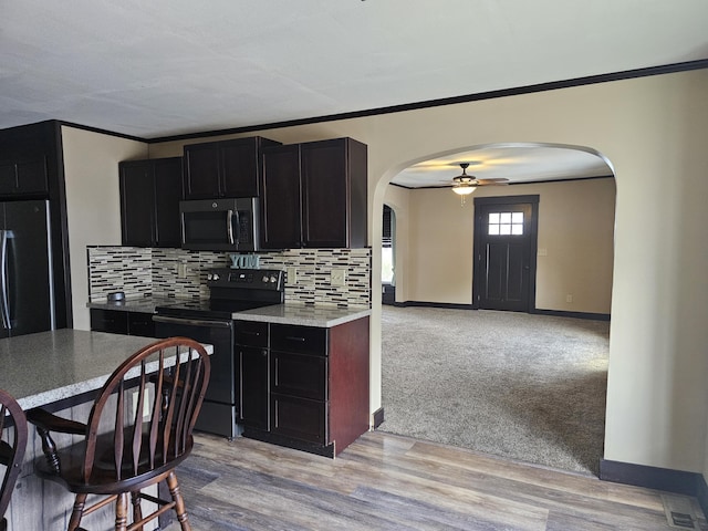 2 E Main St, Fletcher, OH 45326 - kitchen featuring stainless steel appliances, arched walkways, crown molding, tasteful backsplash, and dark cabinetry