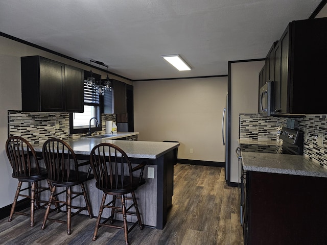 2 E Main St, Fletcher, OH 45326 - kitchen with a peninsula, stainless steel appliances, backsplash, dark wood finished floors, and ornamental molding