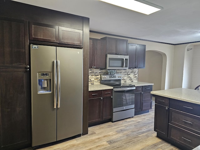 2 E Main St, Fletcher, OH 45326 - kitchen with stainless steel appliances, arched walkways, backsplash, light wood finished floors, and dark brown cabinetry