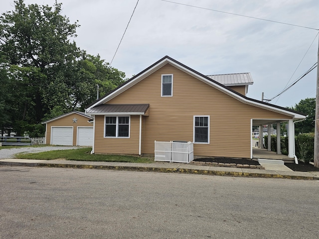 2 E Main St, Fletcher, OH 45326 - view of front facade with a detached garage, an outbuilding, a metal roof, and a porch