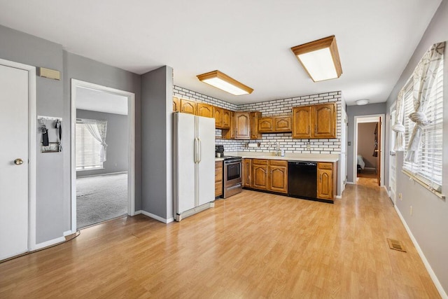 1405 Providence Ave, Springfield, OH 45503 - kitchen featuring freestanding refrigerator, dishwasher, stainless steel range, light countertops, and brown cabinets