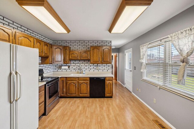 1405 Providence Ave, Springfield, OH 45503 - kitchen with black dishwasher, freestanding refrigerator, electric range, and brown cabinetry