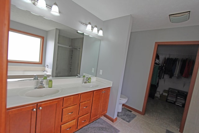 bathroom with a shower stall, toilet, tile patterned flooring, and a sink