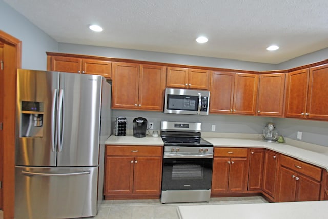 kitchen with brown cabinets, recessed lighting, stainless steel appliances, and light countertops