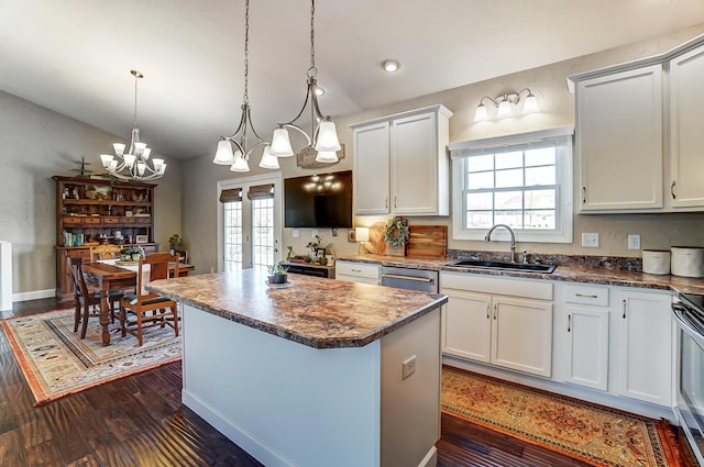 kitchen with dark wood finished floors, plenty of natural light, a kitchen island, and a sink