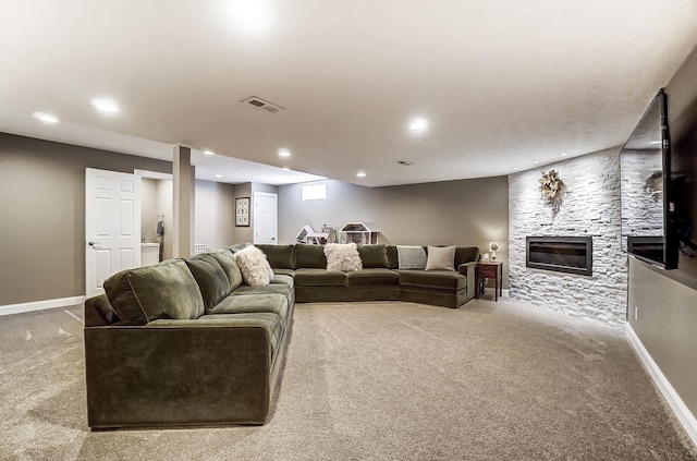 carpeted living area with visible vents, recessed lighting, a large fireplace, and baseboards