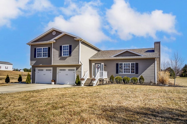 tri-level home featuring a chimney, driveway, an attached garage, and a front yard