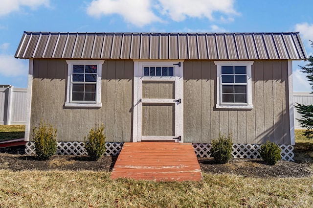 view of front facade featuring metal roof, a storage shed, and an outdoor structure