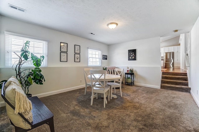 dining area featuring baseboards, visible vents, carpet floors, and a textured ceiling