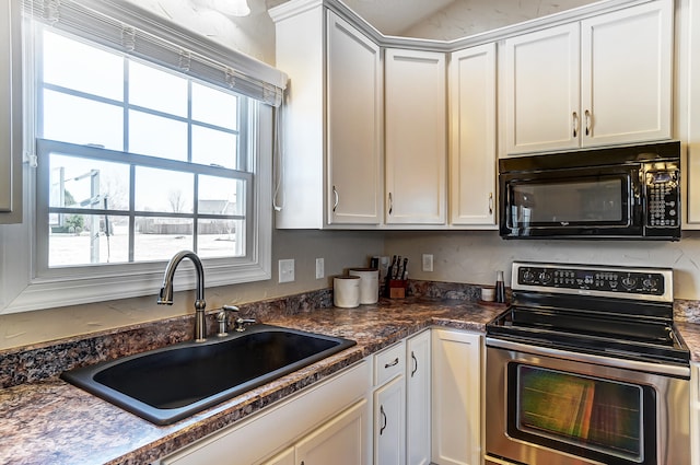 kitchen featuring dark countertops, black microwave, stainless steel electric range, white cabinets, and a sink