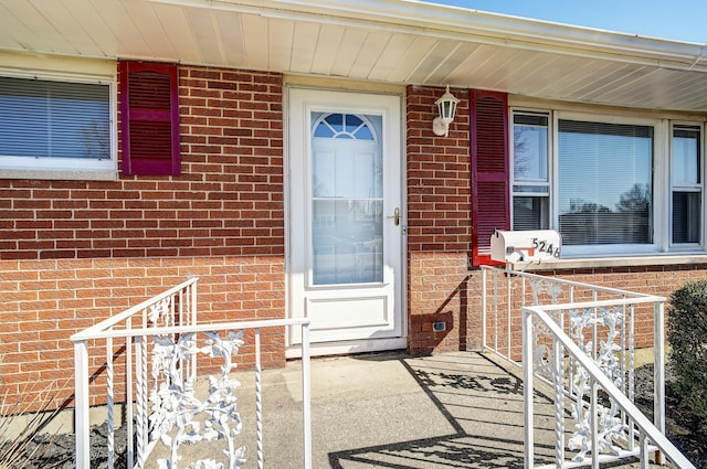 doorway to property featuring brick siding