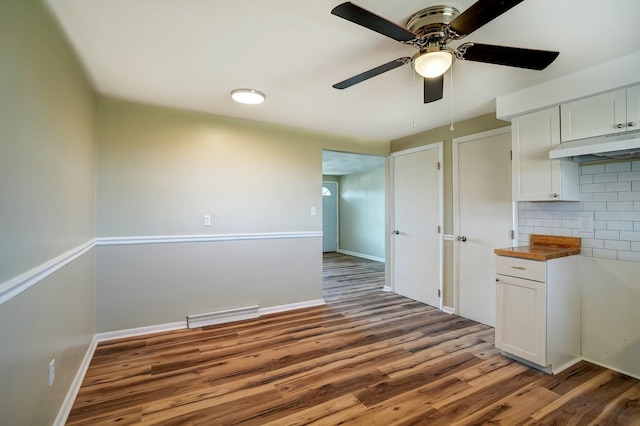 kitchen with visible vents, under cabinet range hood, tasteful backsplash, wood finished floors, and ceiling fan