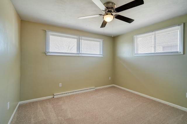 empty room featuring a baseboard heating unit, carpet flooring, baseboards, and ceiling fan