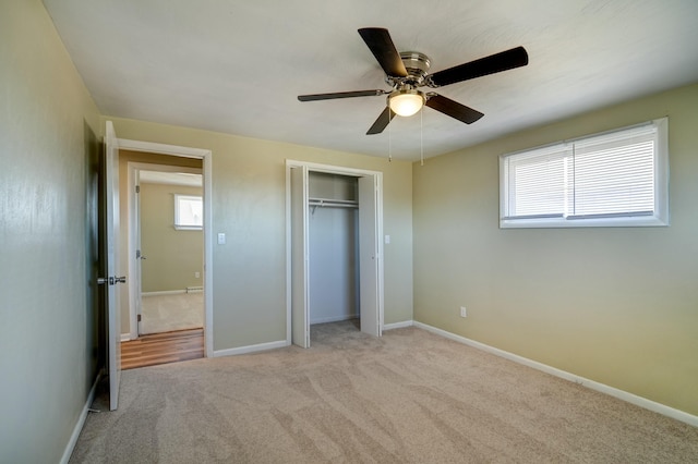 unfurnished bedroom with ceiling fan, carpet, a closet, and baseboards