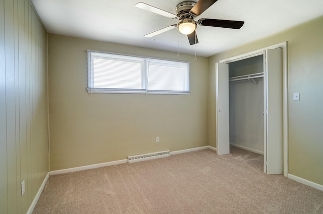 unfurnished bedroom with a baseboard heating unit, a closet, carpet floors, baseboards, and ceiling fan