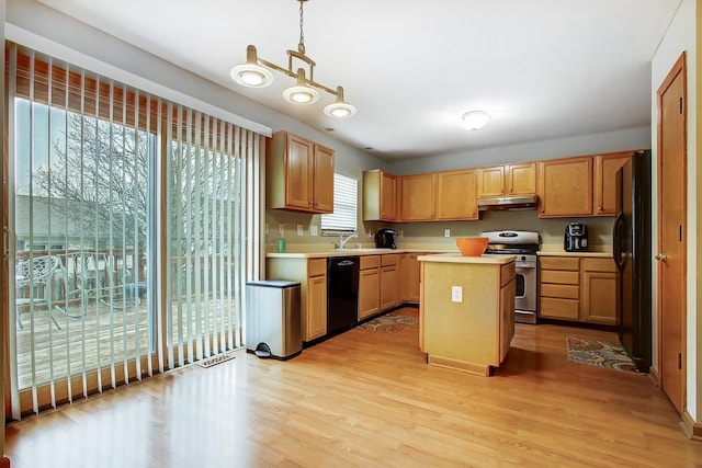 kitchen with sink, a center island, light hardwood / wood-style flooring, hanging light fixtures, and black appliances