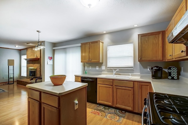 kitchen with pendant lighting, sink, black dishwasher, a kitchen island, and gas range