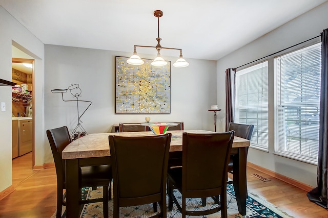 dining space with hardwood / wood-style floors and washer / dryer