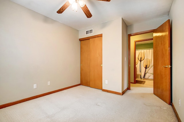 unfurnished bedroom with ceiling fan, light colored carpet, and a closet