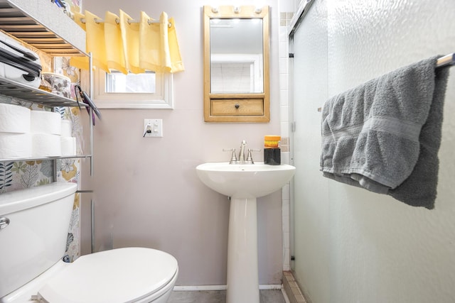 full bathroom with a sink, baseboards, toilet, and a stall shower