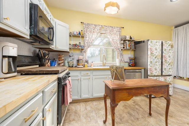 kitchen featuring a sink, stove, black microwave, wood counters, and stainless steel dishwasher