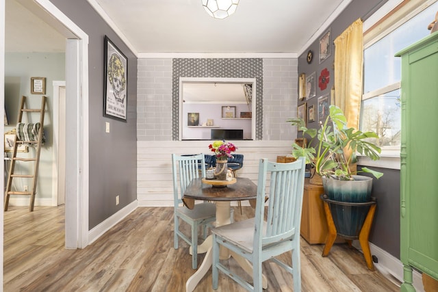 dining space featuring light wood-style flooring and baseboards