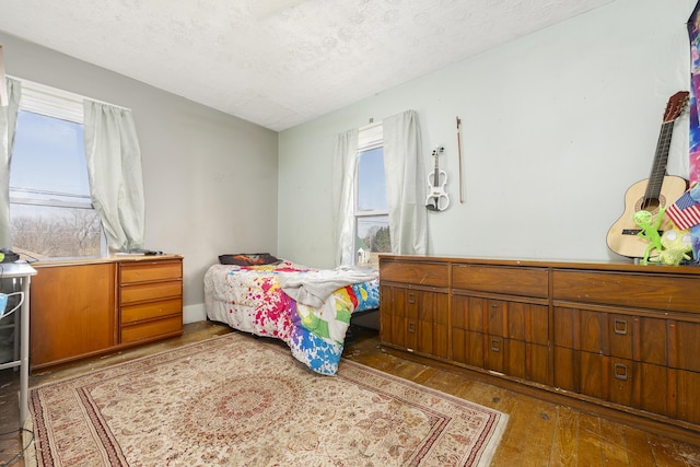 bedroom with a textured ceiling and hardwood / wood-style floors