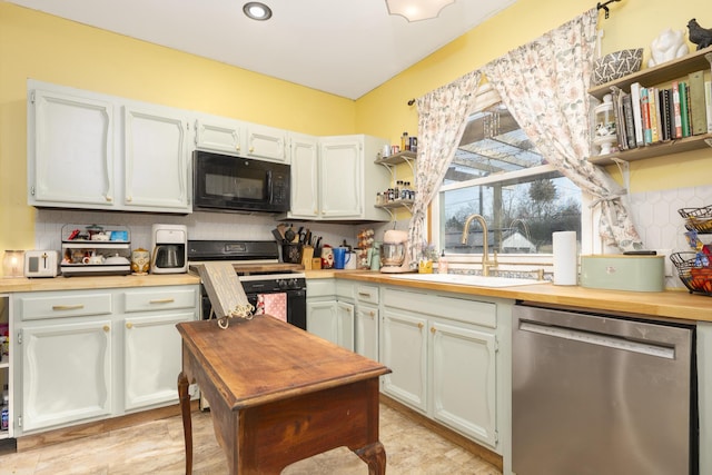 kitchen featuring tasteful backsplash, range with gas cooktop, black microwave, dishwasher, and a sink