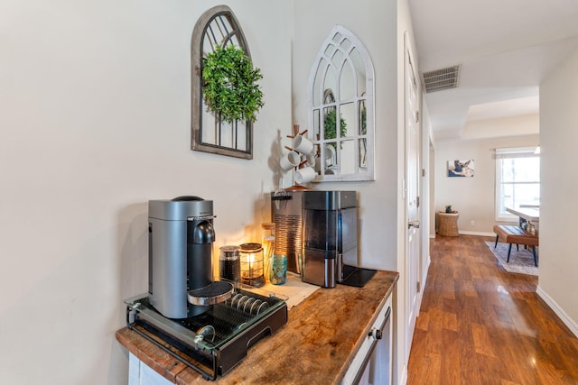 interior space with visible vents, baseboards, and wood finished floors