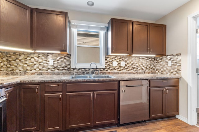 kitchen featuring a sink, light wood-type flooring, tasteful backsplash, and dishwasher