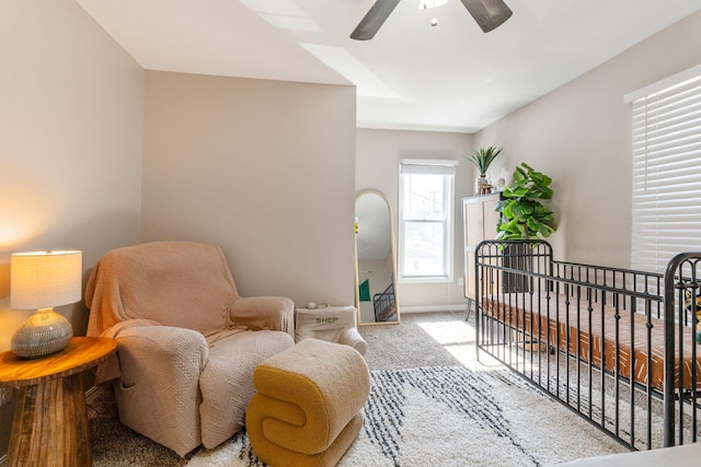 sitting room with baseboards, carpet, and a ceiling fan