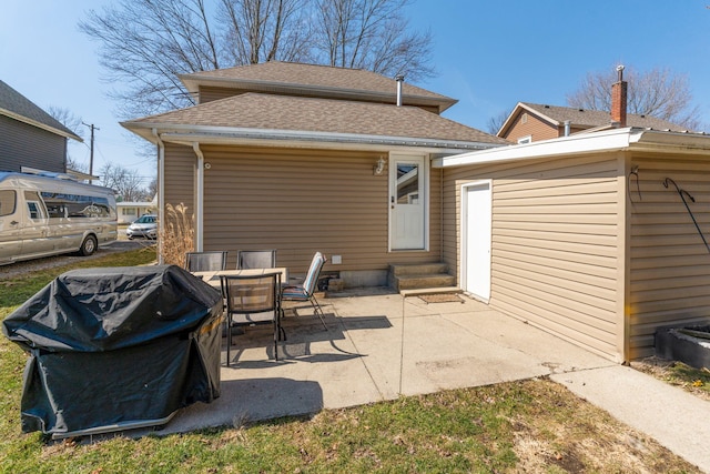 rear view of property featuring a patio, roof with shingles, and entry steps