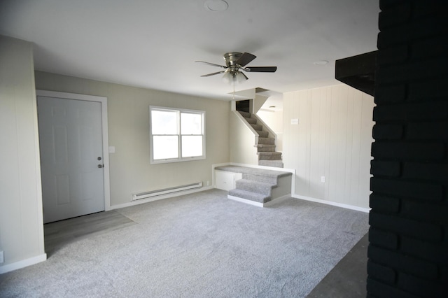 unfurnished living room with a baseboard heating unit, carpet flooring, a ceiling fan, and stairway