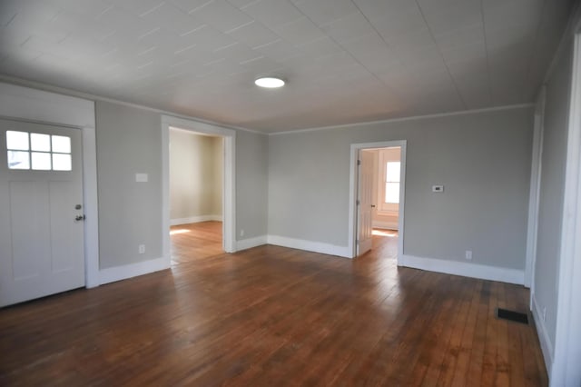 foyer entrance featuring dark wood-type flooring, baseboards, and ornamental molding