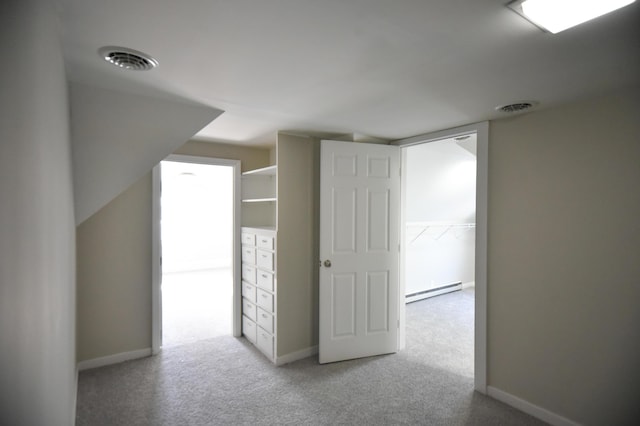 hallway with light colored carpet, visible vents, and a baseboard radiator