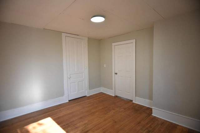 spare room featuring baseboards and wood finished floors