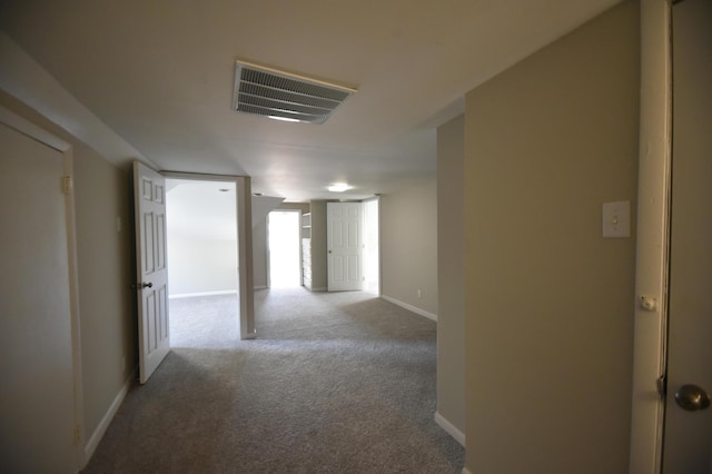 corridor featuring visible vents, baseboards, and carpet flooring