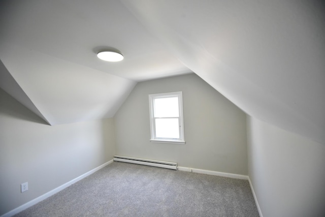 additional living space featuring vaulted ceiling, carpet flooring, baseboards, and a baseboard radiator