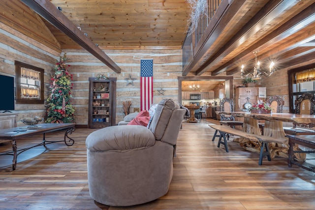 living room with wood finished floors, beam ceiling, and an inviting chandelier